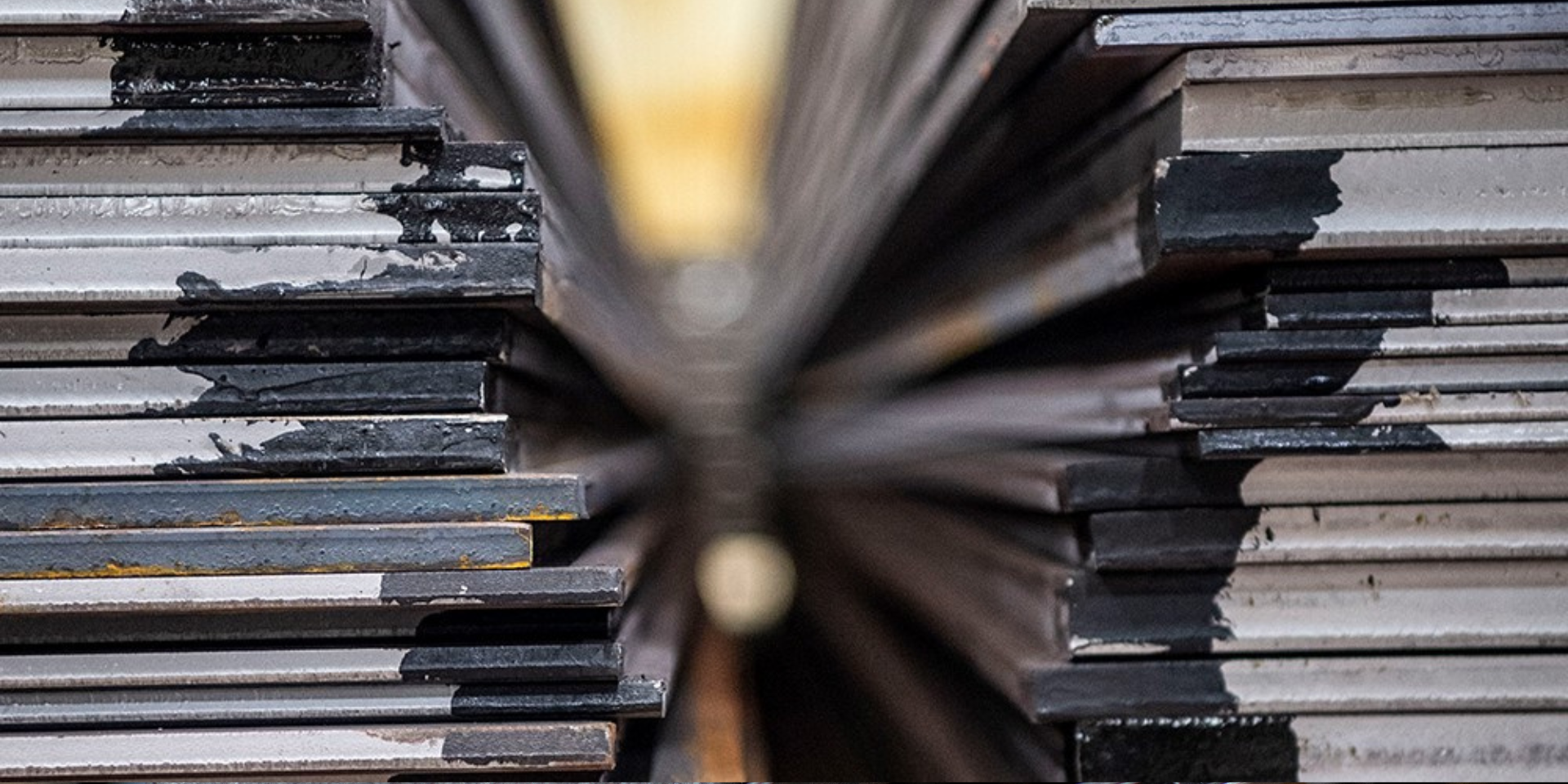 Grob- und Bandbleche nebeneinander auf Lager, zur Veranschaulichung der Unterschiede in Dicke, Form und Anwendung